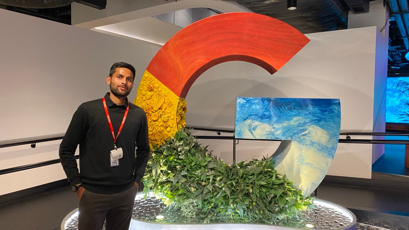 Agrim Sharma beside the Google logo sculpture in the Google Sydney office