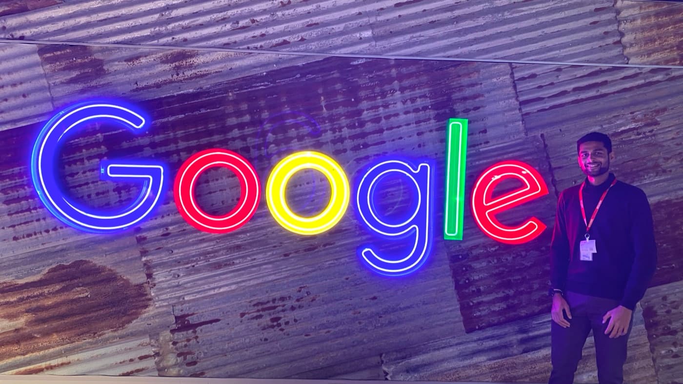 Agrim Sharma beside the neon Google sign in the Google Sydney office
