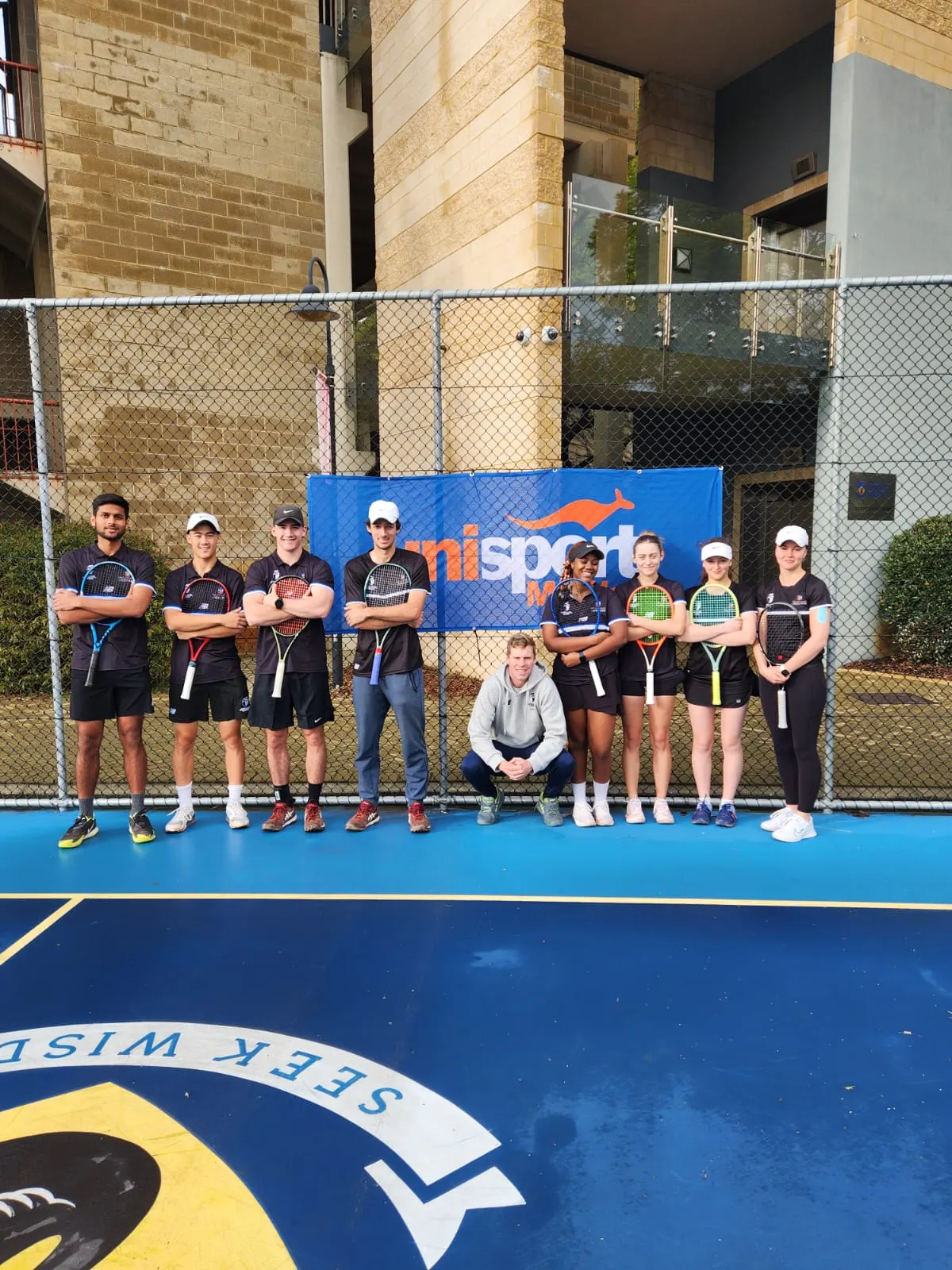 The UTL team lined up on court in Perth, with their coach crouching in front