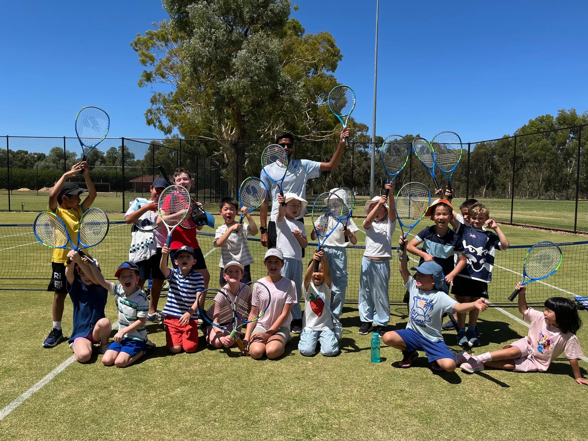 Agrim with a group of young players holding racquets